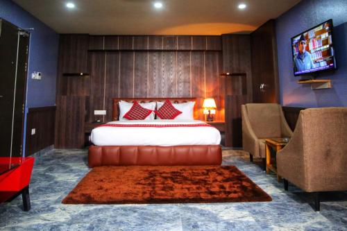 Habitación de hotel con cama y TV en Khanal Hotel en Nepālganj