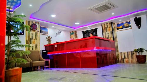 una barra roja en una habitación con iluminación púrpura en Khanal Hotel en Nepālganj