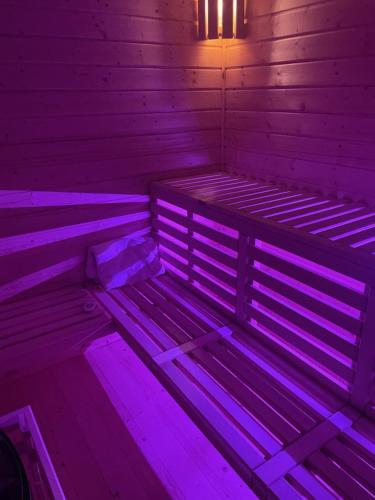 Pokój z fioletowymi światłami na drewnianym łóżku w obiekcie KOLONIA HOTEL w Świdnicy