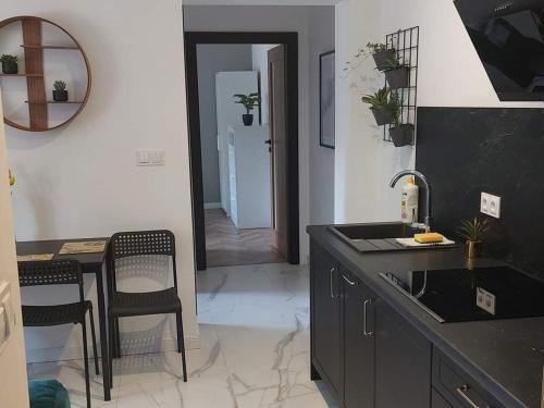 a kitchen with a black counter and a table and chairs at Apartament Królewiecka 22 Centrum Molo jezioro Czos in Mrągowo