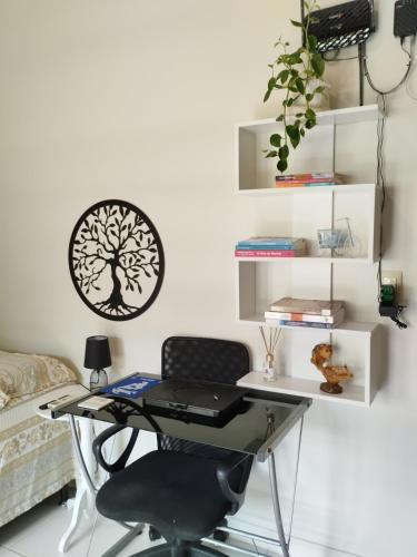 un escritorio en una habitación con una pegatina de árbol en la pared en Quarto Praia do Frances, en Marechal Deodoro