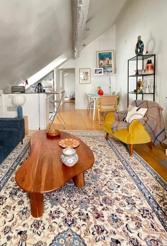 un salon avec une table et un canapé dans l'établissement Charmant appartement parisien, à Paris