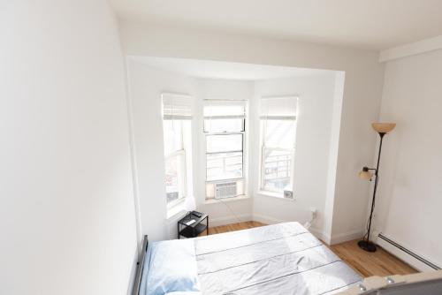 Dieses weiße Zimmer verfügt über Fenster und ein Bett. in der Unterkunft Deluxe Studio Apt Close to NYC in Union City