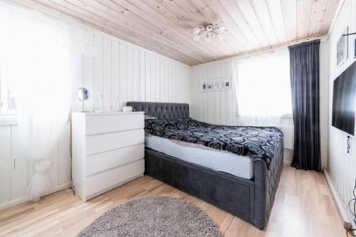 ein Schlafzimmer mit einem Bett, einer Kommode und einem Fenster in der Unterkunft A wonderful estate of two houses for all seasons! in Trysil