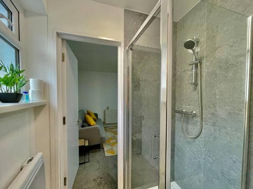 a bathroom with a shower with a glass door at Modern Cosy 1 Bed Ilford Home - Free Parking in Ilford