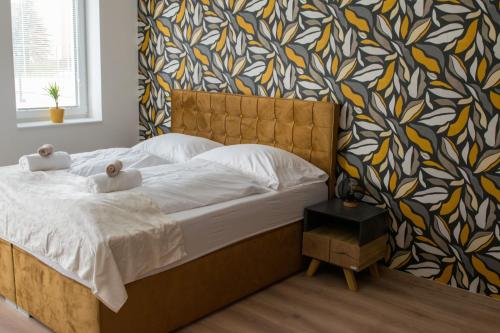 a bedroom with a large bed with a colorful wall at Luxusní Apartmán NMNM Essence in Nové Město na Moravě