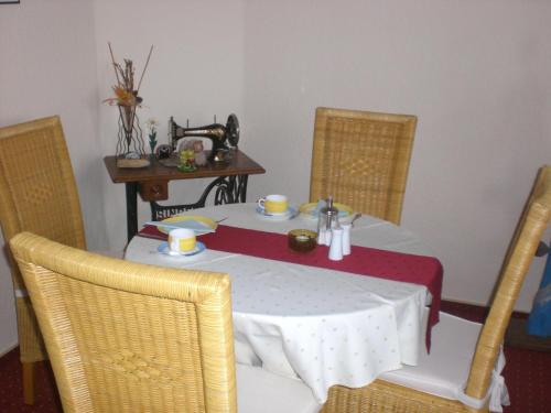 a table and chairs with a white table and a table at Pension Villa Sophia in Sassnitz