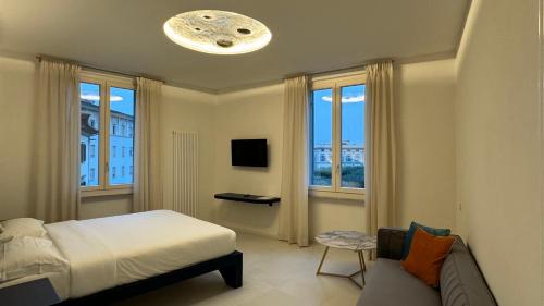 a bedroom with a bed and a couch and windows at Sette Note Guest House in Arezzo
