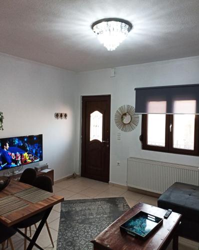 a living room with a couch and a tv at Vaikouzis Houses in Samothráki