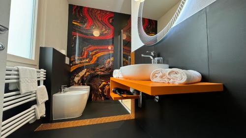 un baño con lavabo y una pintura en la pared en Sette Note Guest House, en Arezzo