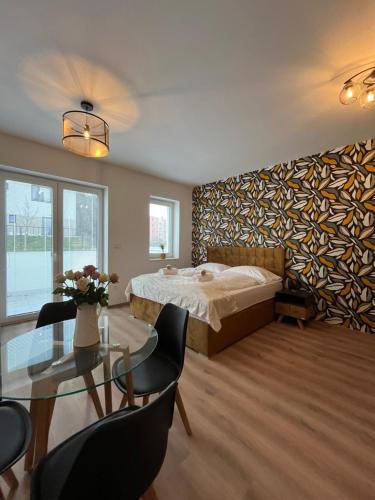 a bedroom with a bed and a table with chairs at Luxusní Apartmán NMNM Essence in Nové Město na Moravě