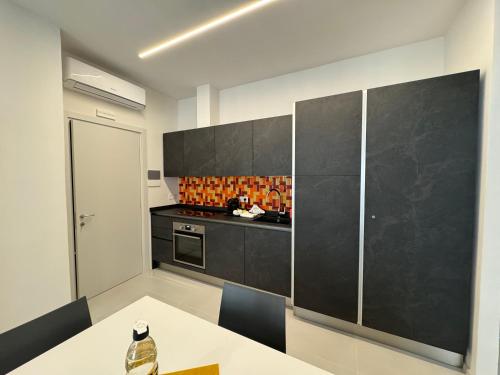a kitchen with a white table and a black counter top at Sette Note Guest House in Arezzo