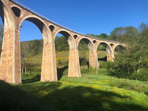 a bridge with many arches on top of a field at Chambre d'Hôtes Côté Glycine in Juré