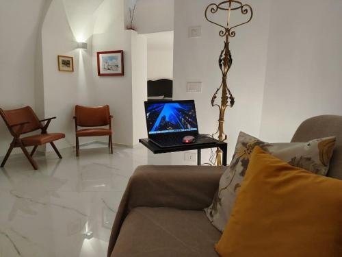 a living room with a couch and a laptop on a table at LianHome b&b "Volte" in Lucera
