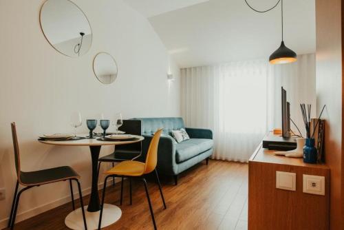 a living room with a table and a couch at Gerês Adelaide Studios in Geres