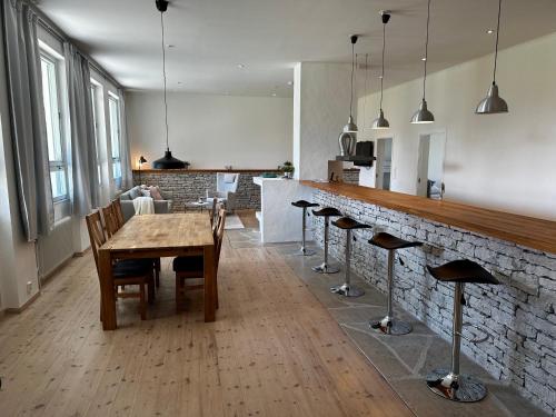 a kitchen with a wooden table and chairs and a bar at Hangvar Skola Biologisalen in Lärbro