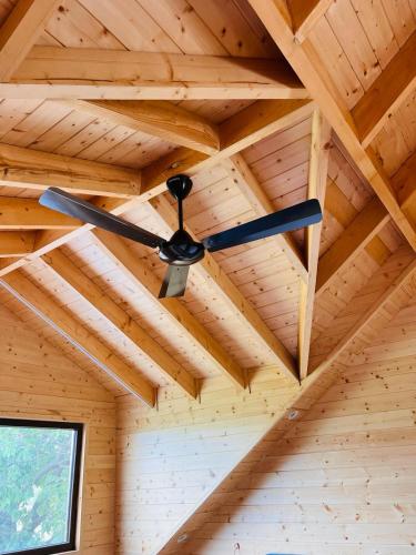 a ceiling fan hanging from a wooden ceiling at Yellow Pine Luxury Cottage in Jammu