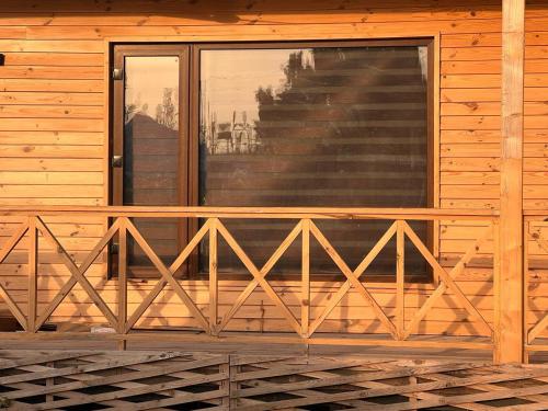 a wooden railing on the front of a cabin at Yellow Pine Luxury Cottage in Jammu