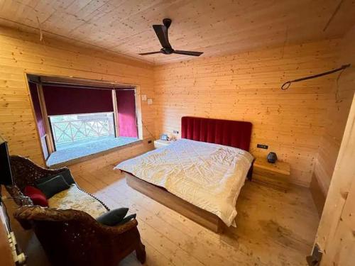 ein Schlafzimmer mit einem Bett in einem Holzzimmer in der Unterkunft Yellow Pine Luxury Cottage in Jammu
