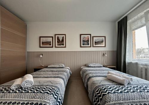 two beds in a room with a window at Homely apartment in Kėdainiai in Kėdainiai