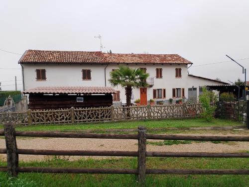 ein weißes Haus mit einem Zaun davor in der Unterkunft La vigna in Costigliole dʼAsti