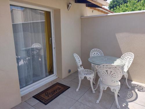 a patio with a table and chairs on a balcony at Gîte Le Jasmin in Le Thor