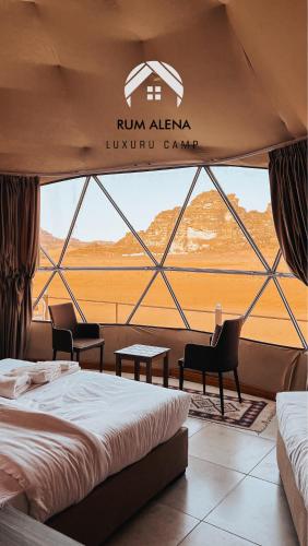 a room with a bed and chairs and a window at RUM ALIENA LUXURY CAMP in Wadi Rum