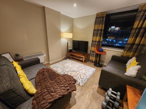 salon z kanapą i telewizorem w obiekcie Joyful Abode - Live in the Heart of Manchester w Manchesterze
