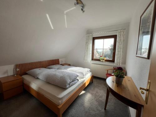 a bedroom with a bed and a table and a window at Ferienwohnung Dresden in Dresden