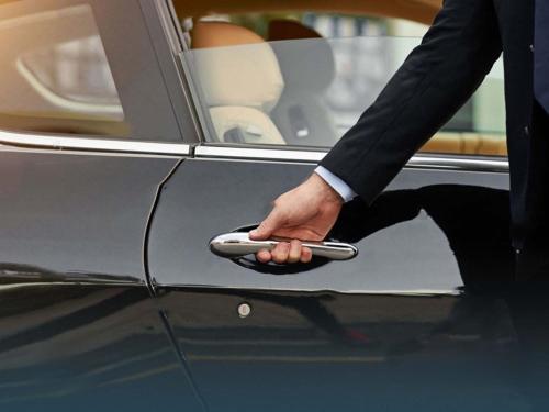a man holding a remote control in a car door at فندق أبراج الريان المكية Al Rayyan Makiya Towers Hotel 1 in Makkah