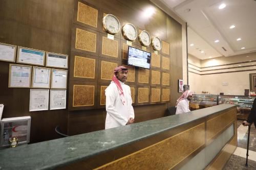 a man standing at a counter in a restaurant at فندق أبراج الريان المكية Al Rayyan Makiya Towers Hotel 1 in Makkah
