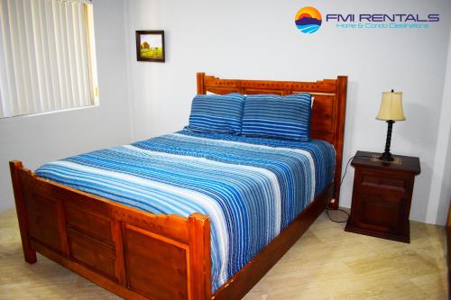 Una cama en un dormitorio con una manta de rayas azules en Marina Pinacate Villa-12, en Puerto Peñasco