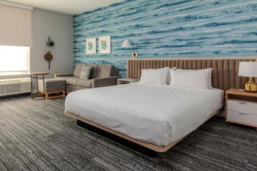 TownePlace Suites by Marriott Chesterfield في Chesterfield: غرفة نوم بسرير ولوحة للمحيط
