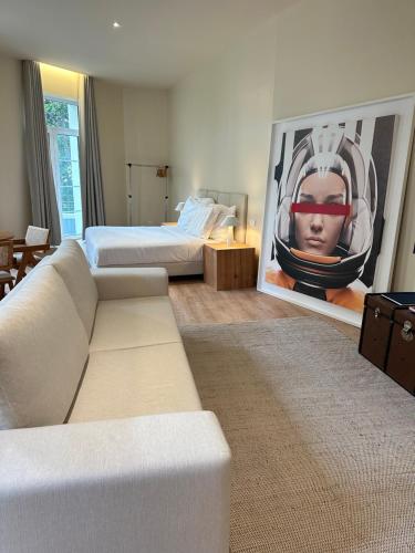 a living room with a couch and a painting of a man at Downtown collection apartments II in Funchal