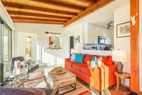 a living room with a red couch and a table at Morongo Star Ranch - Rolling Country Hills w Pool in Morongo Valley
