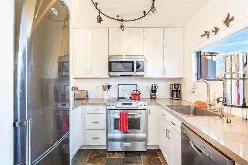 a kitchen with white cabinets and a stainless steel refrigerator at Morongo Star Ranch - Rolling Country Hills w Pool in Morongo Valley