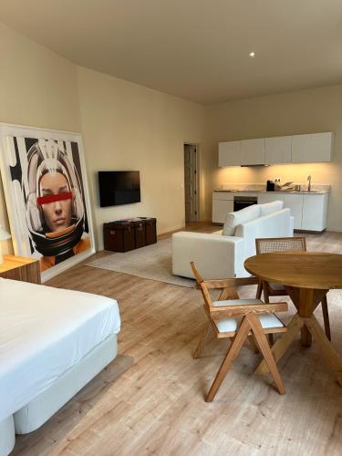 a bedroom with a bed and a table and a kitchen at Downtown collection apartments II in Funchal