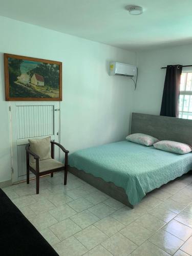 a bedroom with a bed and a chair in it at Posada Nativa Miss Nova in San Andrés