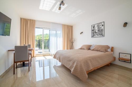 a bedroom with a bed and a desk and a window at White House Radac Peja in Peje