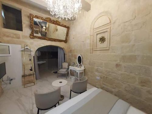 uma sala de estar com uma mesa e cadeiras e um espelho em Casal Annunzia Boutique B&B Accomodation em Tarxien