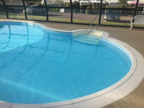 une grande piscine bleue dans un parking dans l'établissement Maison Batz-sur-Mer, plage à 5 minutes, à Batz-sur-Mer