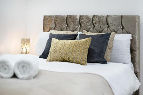 een groot wit bed met kussens bij 2Bd Flat Opp Harrods - Sleeps 5 in Londen