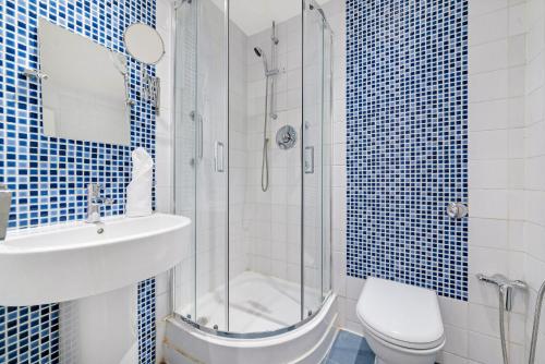 a bathroom with a shower and a sink and a toilet at 2Bd Flat Opp Harrods - Sleeps 5 in London