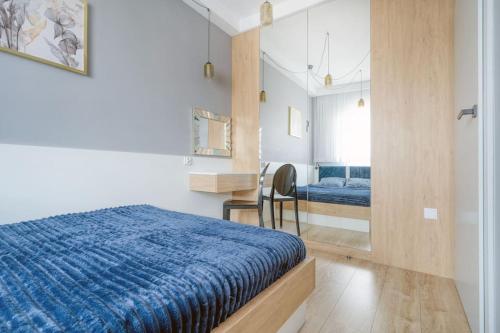 ウッチにあるGolden Apartments Łodz&G147Aのベッドルーム(青いベッド1台、鏡付)