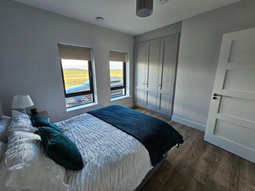 - une chambre avec un grand lit et 2 fenêtres dans l'établissement Inish Glóra, à Belmullet