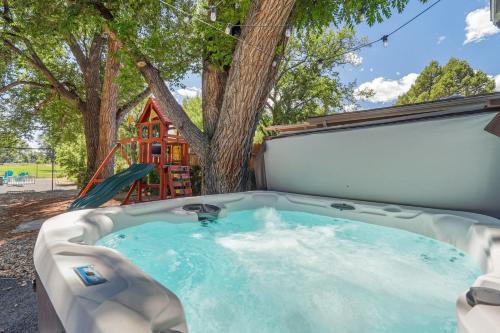 a hot tub in a backyard with a tree at Mulligan Magic - Golf Hot Tub Fire Pit Scenic View in Colorado Springs