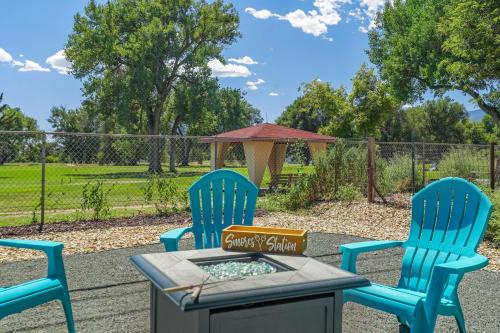 two blue chairs and a table in a yard at Mulligan Magic - Golf Hot Tub Fire Pit Scenic View in Colorado Springs