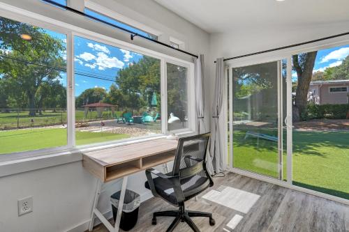 a home office with a desk and large windows at Mulligan Magic - Golf Hot Tub Fire Pit Scenic View in Colorado Springs