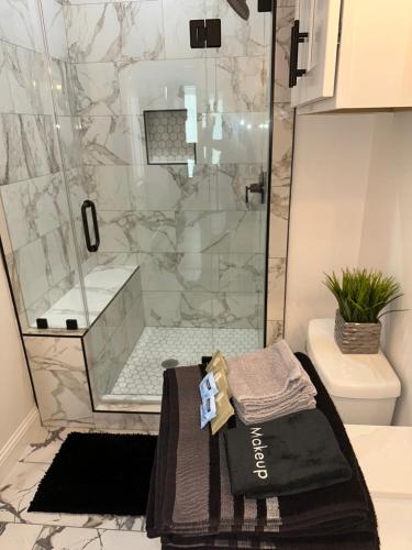 a bathroom with a shower with a black towel on a sink at Luxury Urban Oasis -10 Mins to NRG, Med Ctr & DT! in Houston