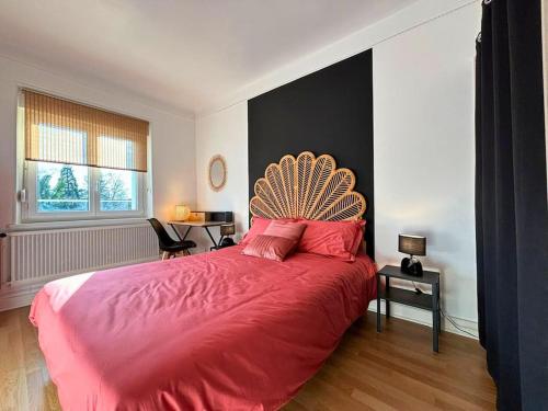 een slaapkamer met een groot bed en een rode deken bij La Vue sur la Digue in Verdun-sur-Meuse